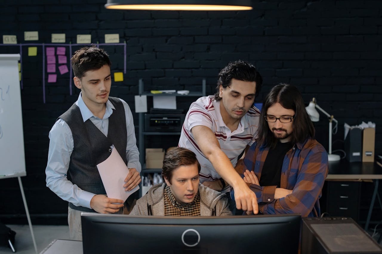 Home Group of professionals discussing a project at a computer in a modern office environment.